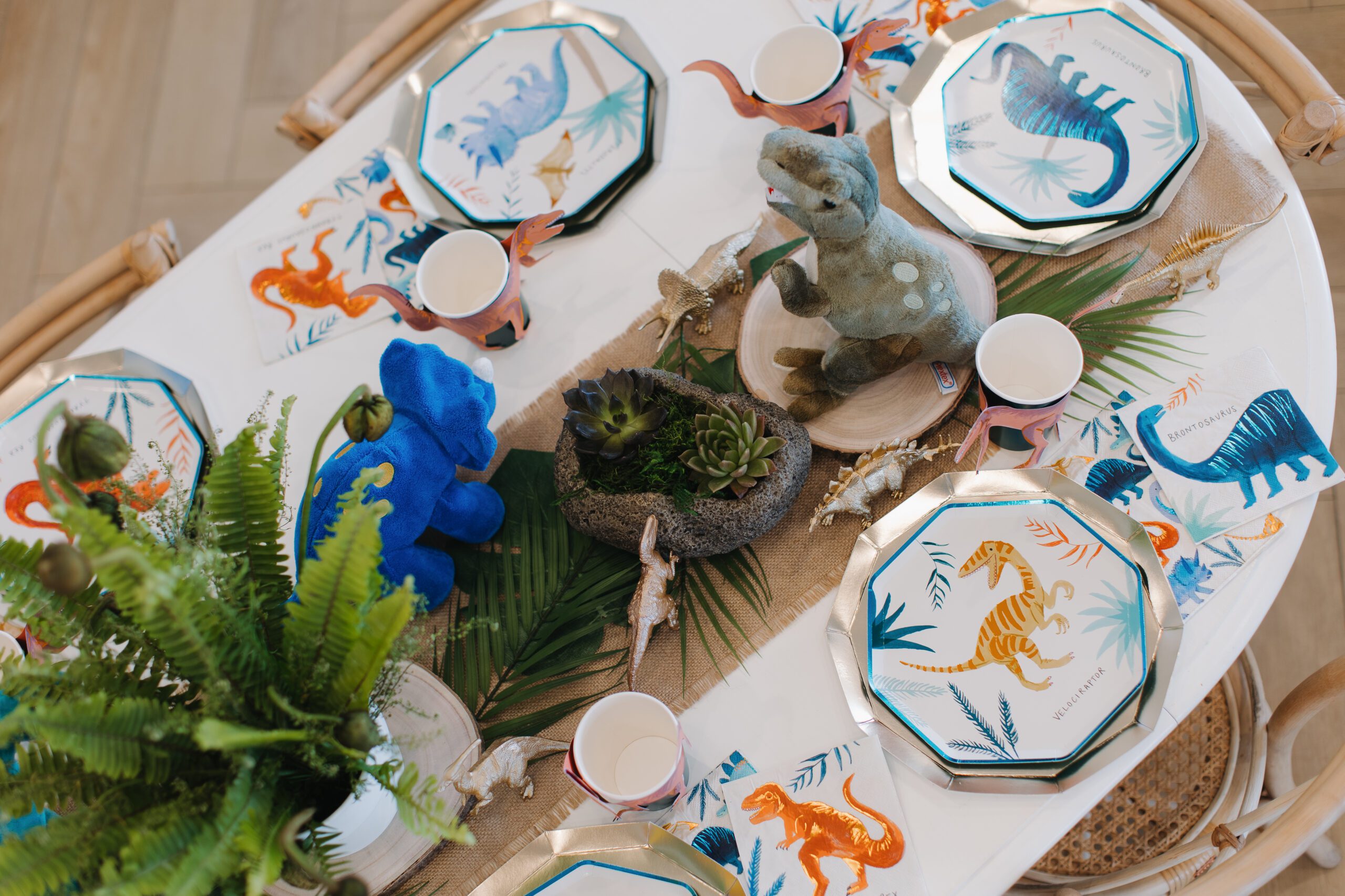 Luxury dinosaur-themed children's birthday party table decor with custom place settings at The Little Play Avenue, Phoenix, AZ