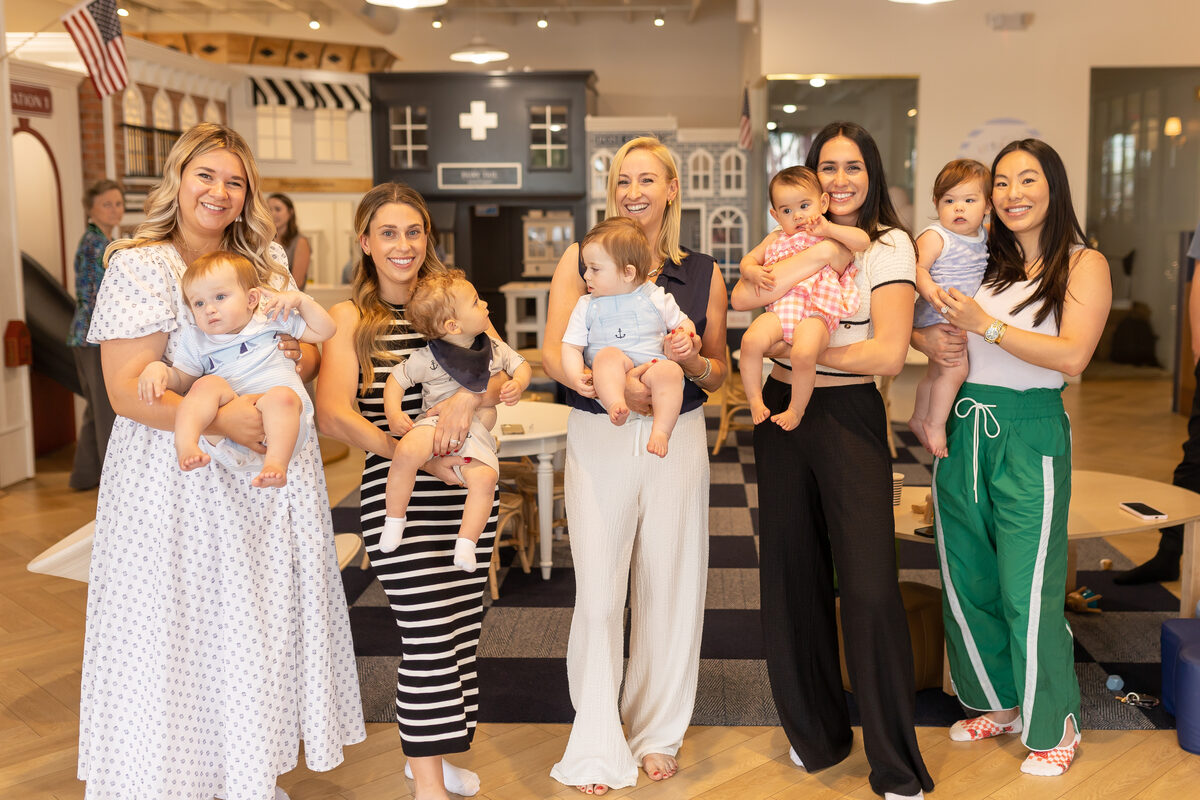 Moms and babies gathered on the play floor for a group photo