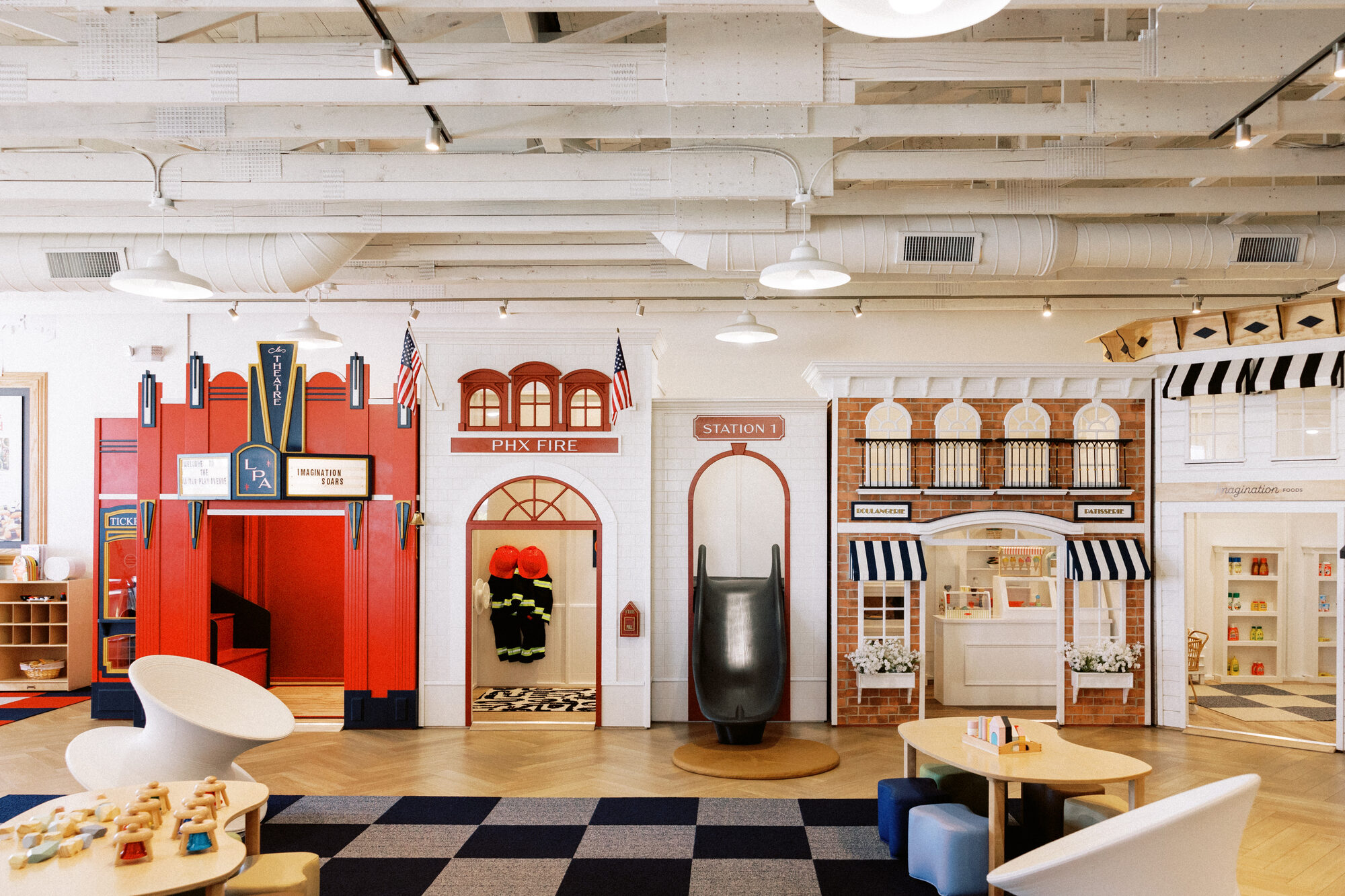 The Little Play Avenue play floor with fire station, storefronts, slide, and seating
